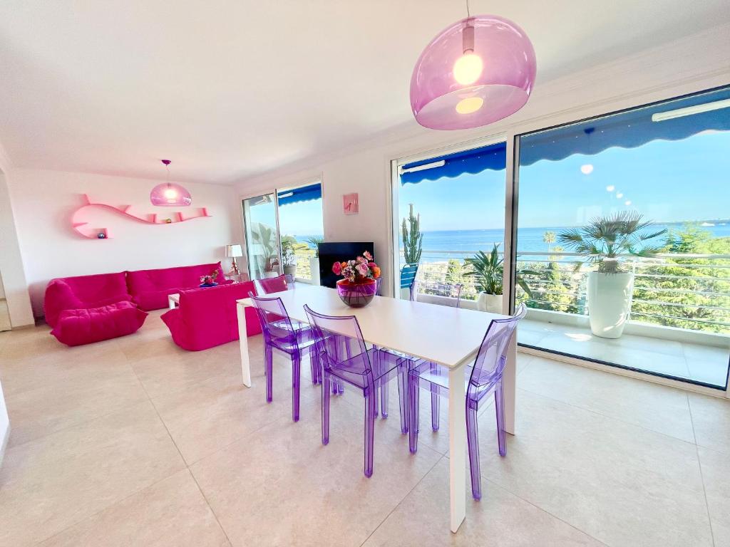 une salle à manger et un salon avec une table et des chaises dans l'établissement Royal Pink - Appartement design - Vue de rêve - Parking gratuit, à Cannes