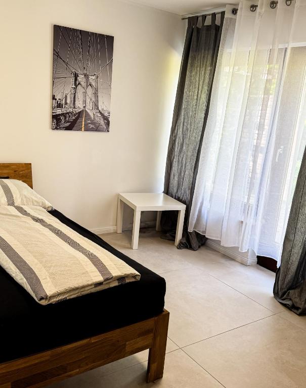 ein Schlafzimmer mit einem Bett und einem Tisch und Fenstern in der Unterkunft Haus 2-4P - 2Zi - Aurora Hamburg in Appel