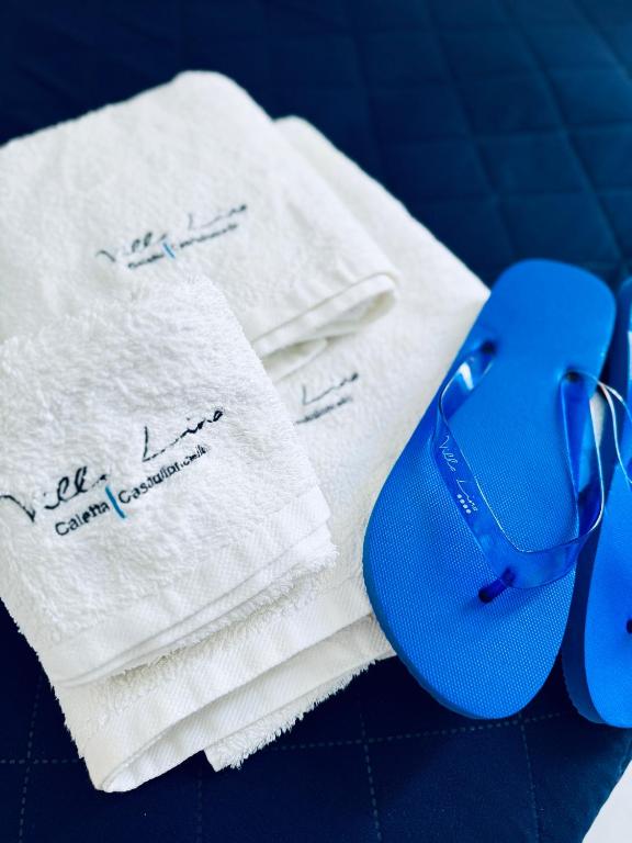 a pair of blue flip flops sitting on top of towels at Villa Lina in Castiglioncello