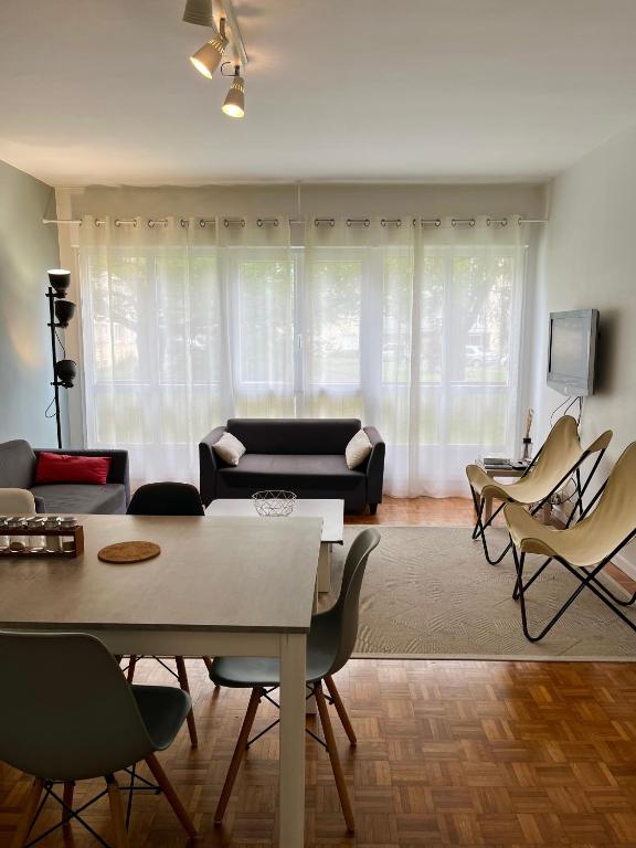 un salon avec un canapé, une table et des chaises dans l'établissement Prométhée - Chambre colocation - Hypercentre Mans, au Mans