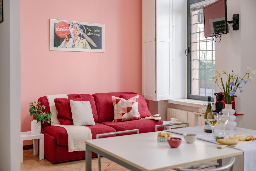a living room with a red couch and a table at Italian Experience-Movie Suite Jesi in Iesi