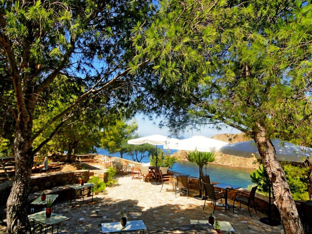 a group of tables and chairs next to a pool at Volissos Holiday Homes in Volissos