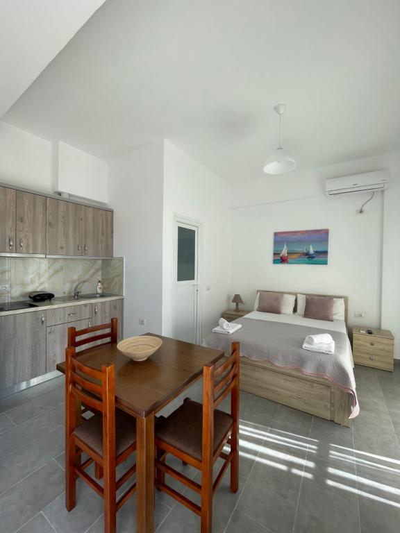 a bedroom with a bed and a wooden table and chairs at GardenView Retreat in Ksamil
