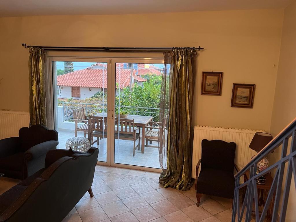 a living room with a sliding glass door to a patio at Villa V in Artemida