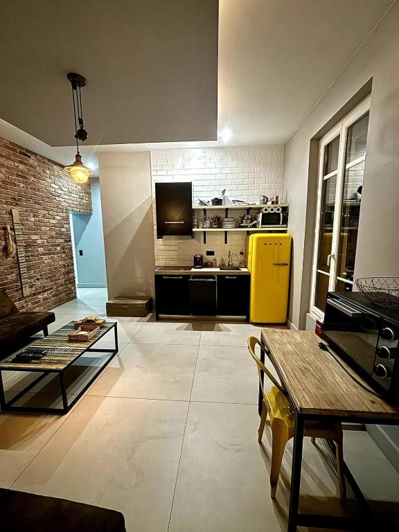 un salon avec un réfrigérateur jaune et une cuisine dans l'établissement Splendide Nice Centre Clim, à Nice