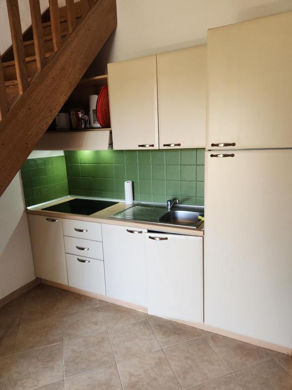 une cuisine avec des armoires blanches et un évier dans l'établissement linguizzetta , les marines de bravone, à Linguizzetta