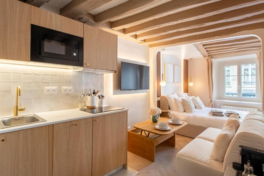 une cuisine et un salon avec un canapé dans l'établissement Louvre - Rivoli - Designer Studio - Sleeps 3P, à Paris