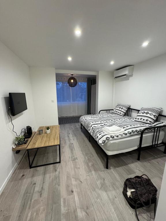 une chambre avec un lit, une table et une télévision dans l'établissement Studio au calme - Villeneuve Loubet, à Villeneuve-Loubet