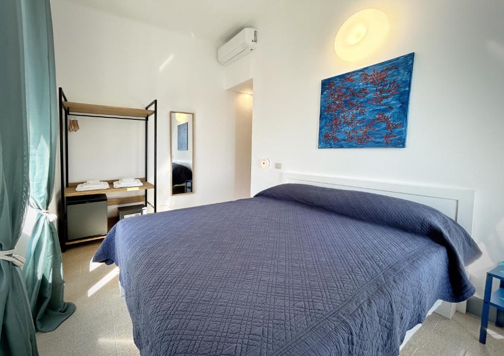 a bedroom with a blue bed and a mirror at Hotel Meublè Agavi in Monterosso al Mare