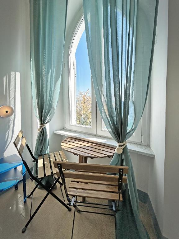 a chair and a table in front of a window at Hotel Meublè Agavi in Monterosso al Mare