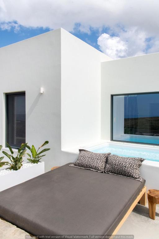 a bedroom with a bed and a swimming pool at Rockaine Suites Eclipse in Tinos
