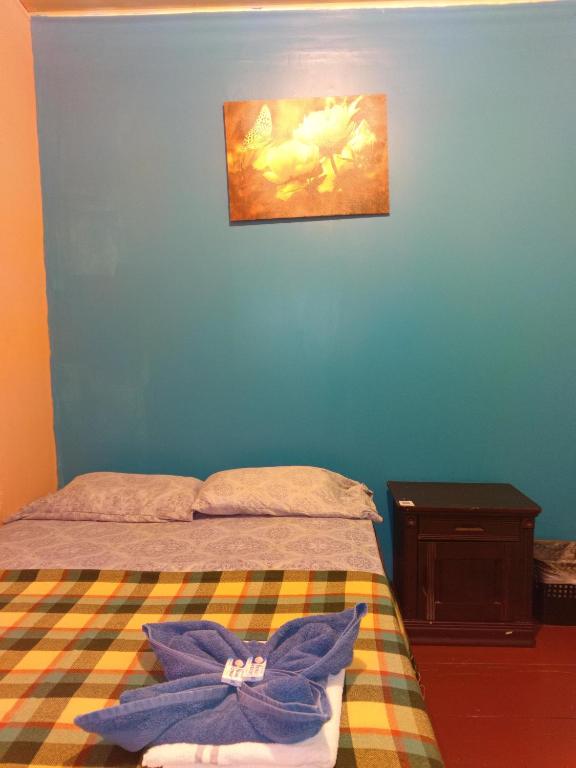 a bedroom with a bed and a painting on the wall at Hostal Vista Boquete in Bajo Boquete