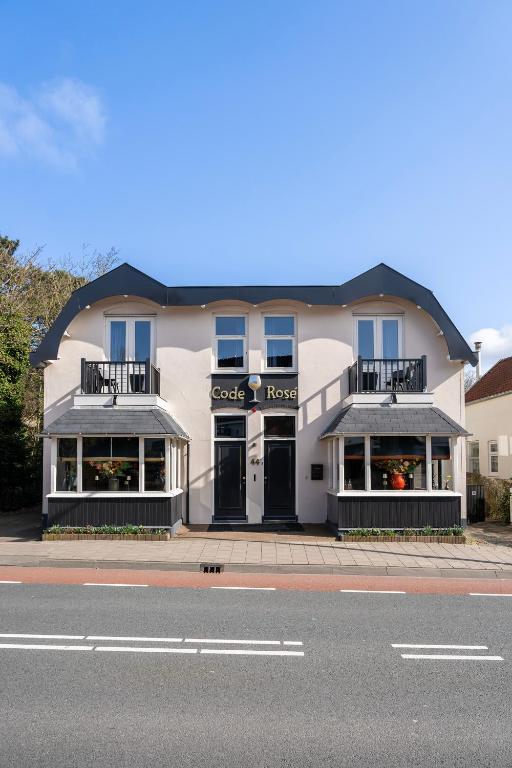 a white building with a store on the side of the street at Boutique Pension Code Rosé in Noordwijk