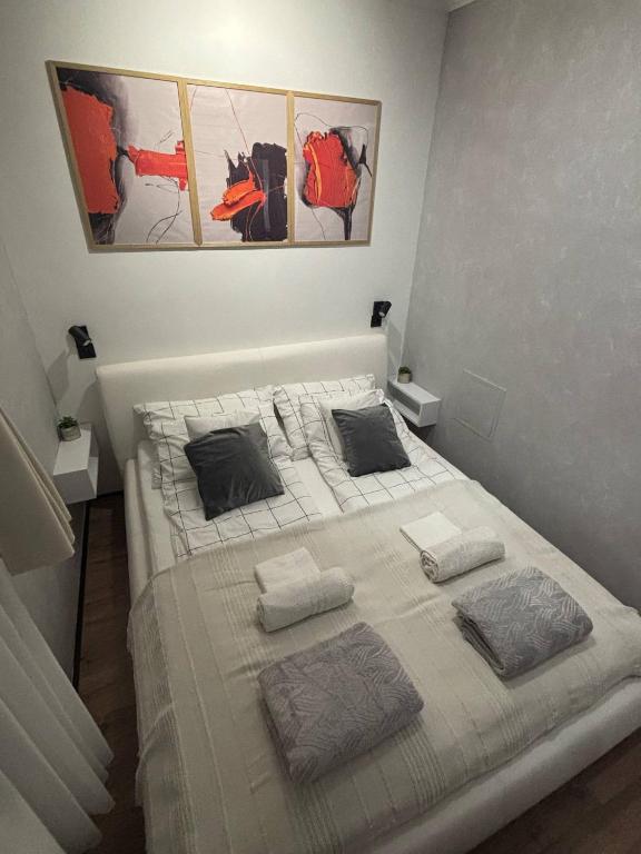 a bedroom with a white bed with two pillows at Taki apartman in Debrecen