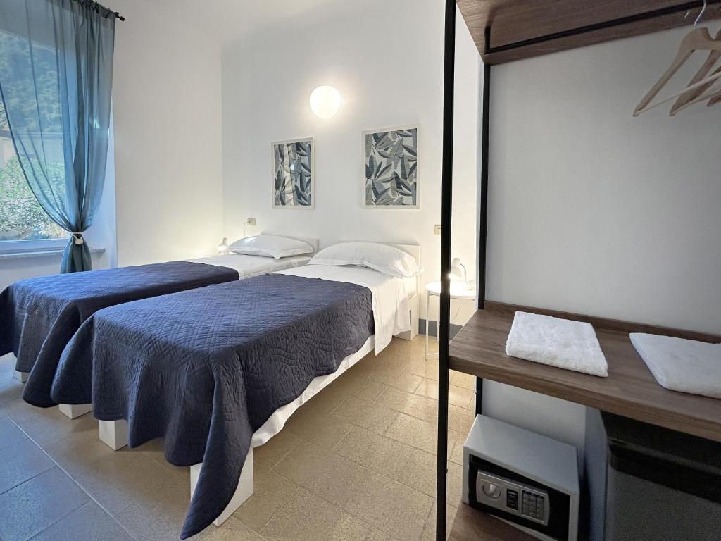 a bedroom with two beds and a television in it at Hotel Meublè Agavi in Monterosso al Mare