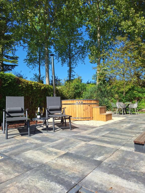 two chairs and a table on a patio at Stelle Maris Wellness, carefree enjoyment! Private Sauna & Hottub in Zeeland, Airco, Free Wifi and more! in Heinkensand