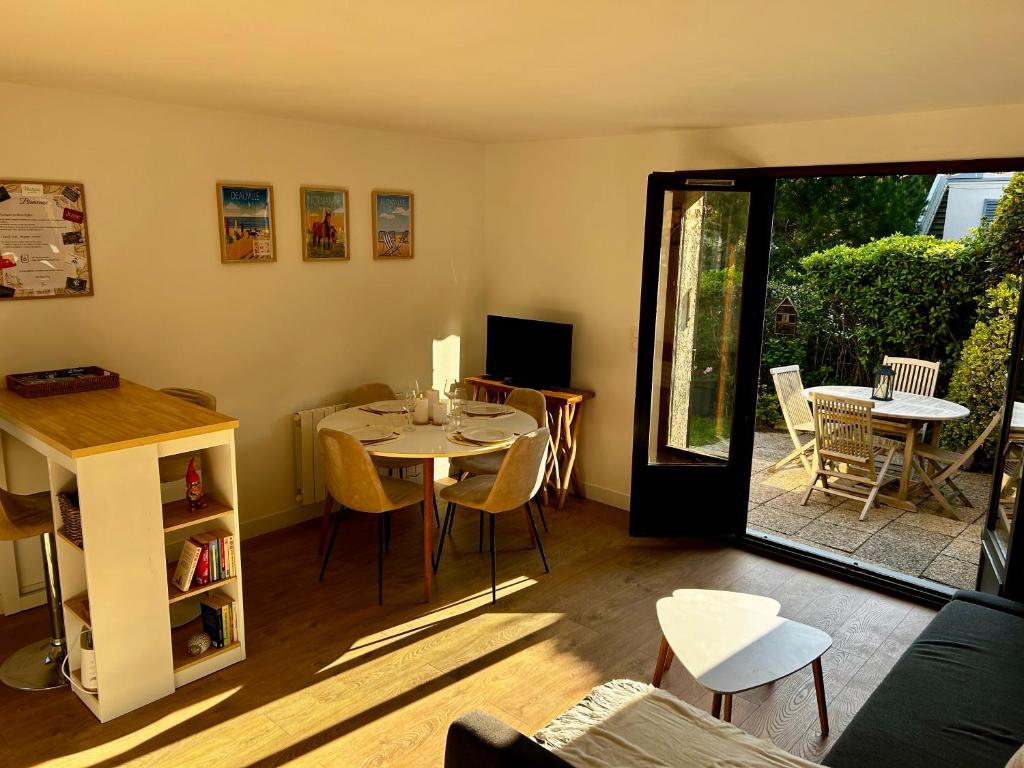 a living room with a table and a dining room at Le Cottage D'Ilona in Blonville-sur-Mer
