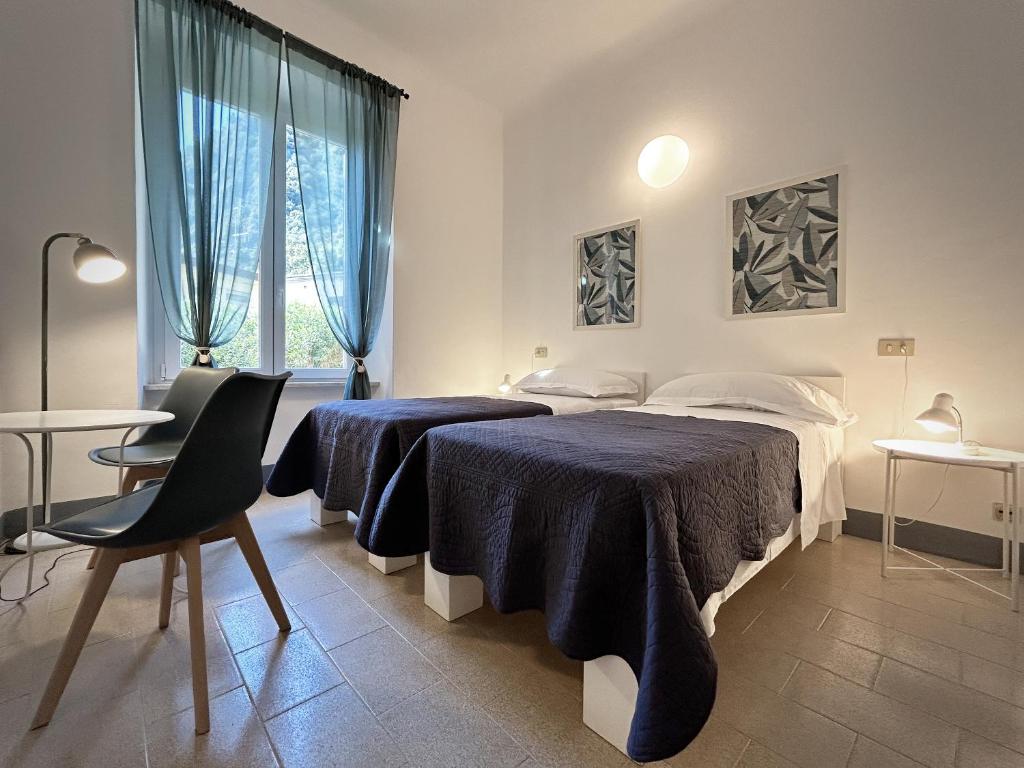 a bedroom with two beds and a table at Hotel Meublè Agavi in Monterosso al Mare