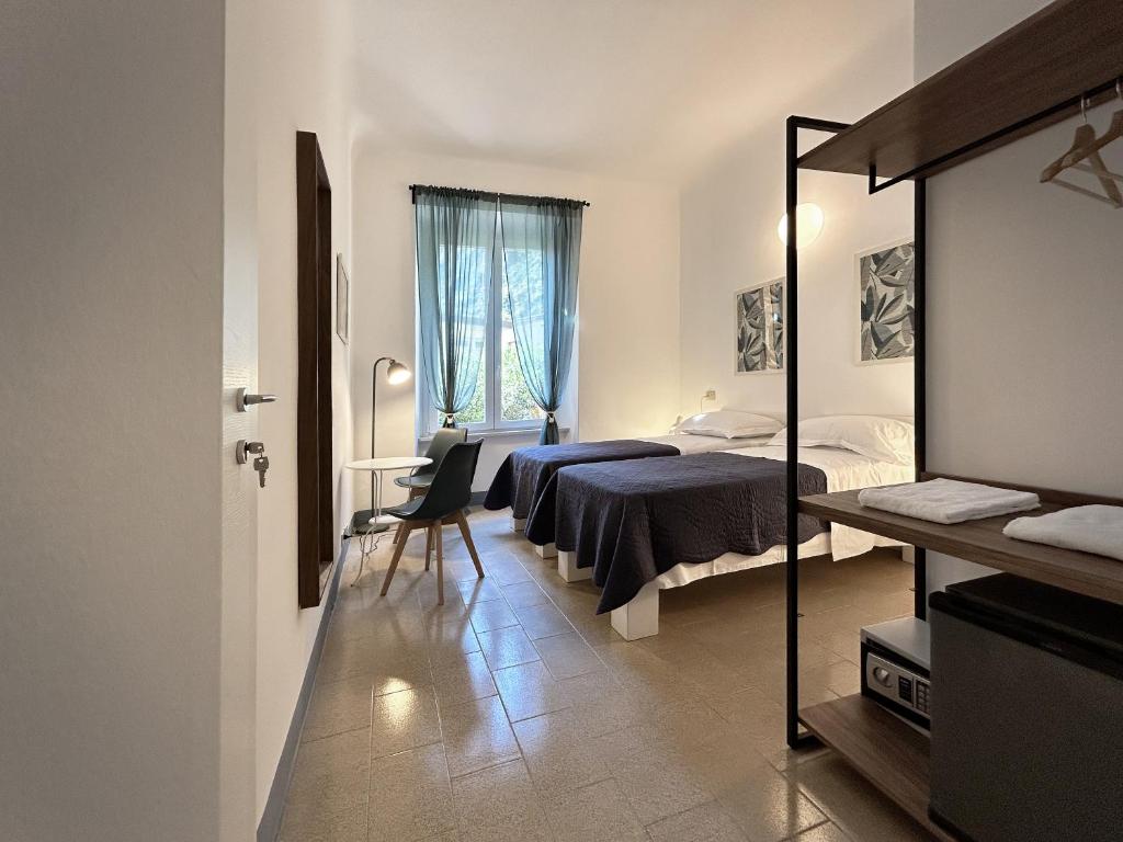 a hotel room with two beds and a mirror at Hotel Meublè Agavi in Monterosso al Mare