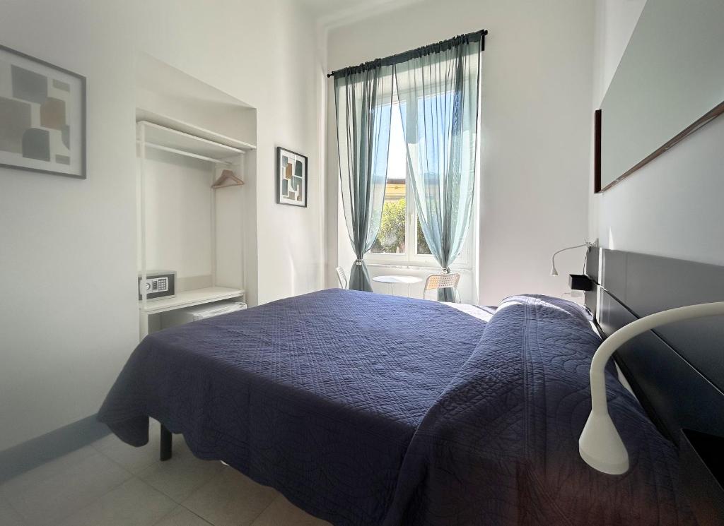 a bedroom with a blue bed and a window at Hotel Meublè Agavi in Monterosso al Mare