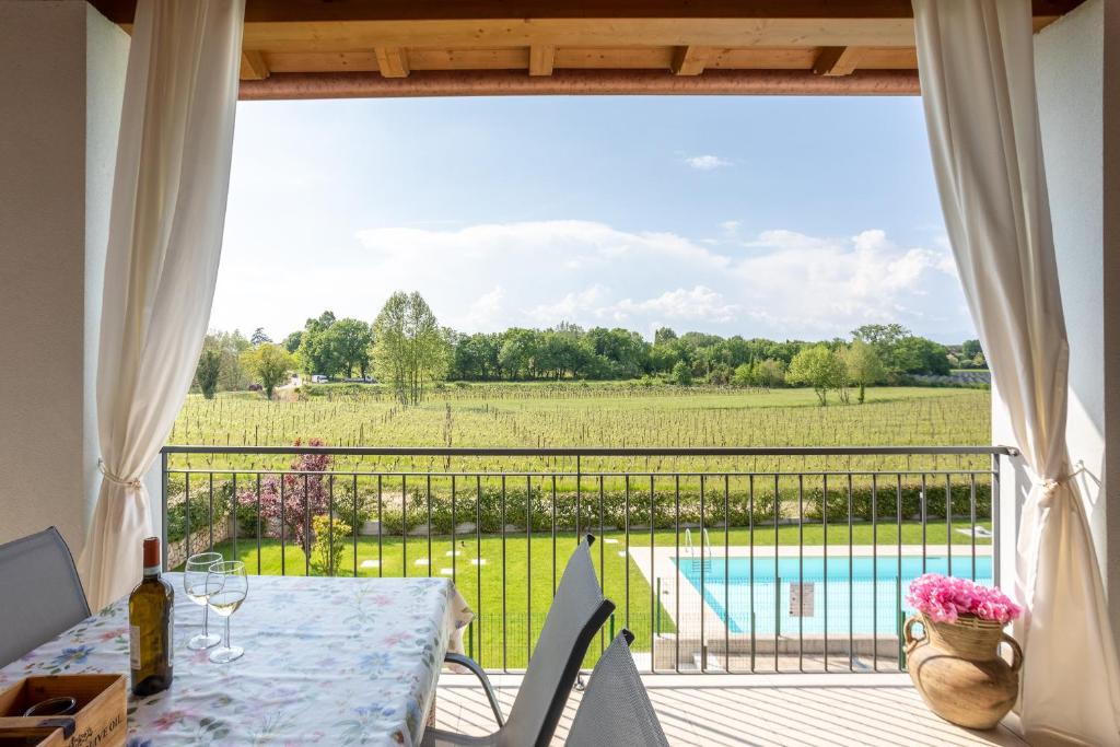 a balcony with a table and a view of a field at Relax tra lago e terme in Pacengo di Lazise