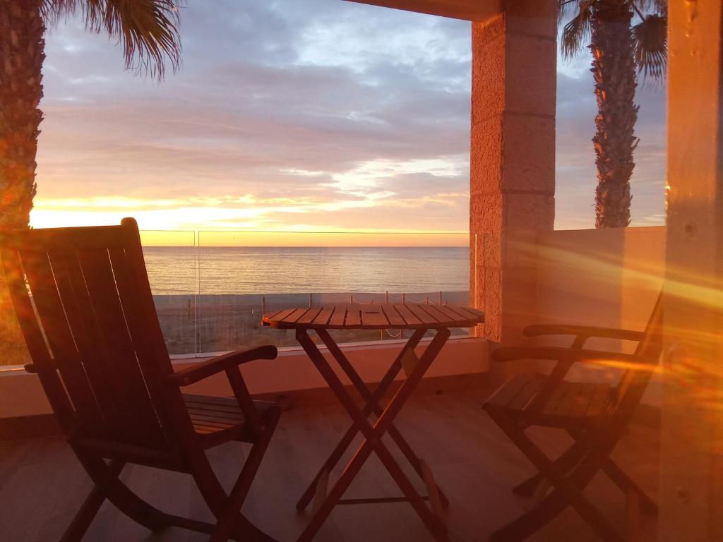 ein Tisch und Stühle auf einem Balkon mit Blick auf das Meer in der Unterkunft Els Vents primera línea playa Puçol in Playa de Mar