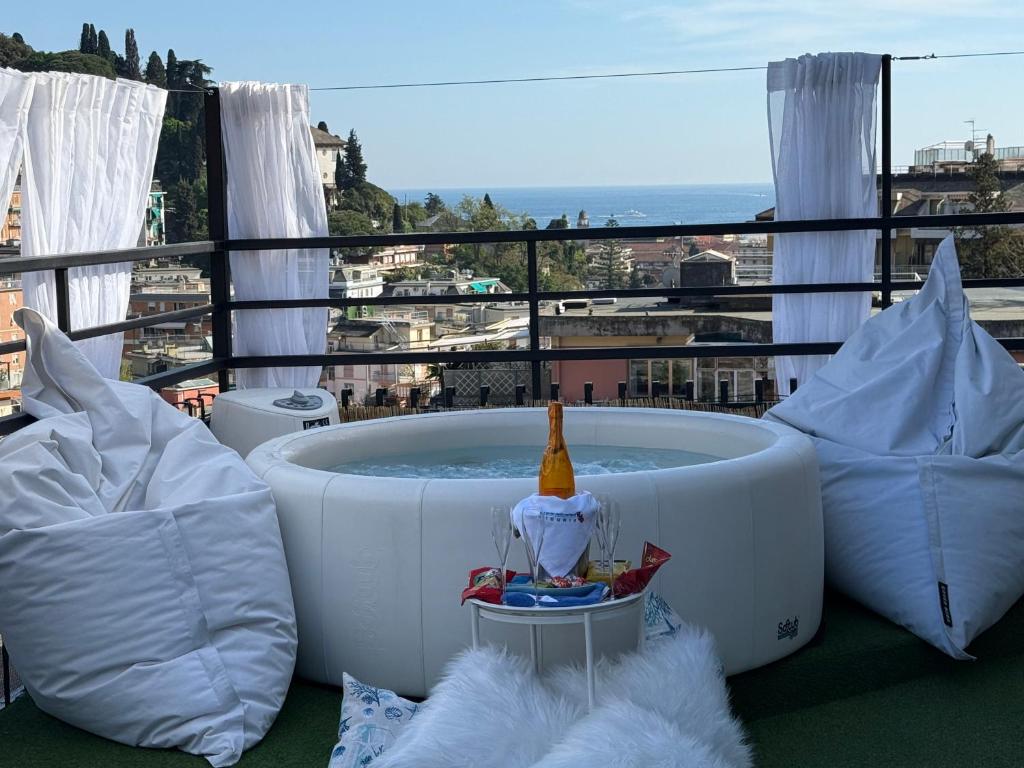 a hot tub on a balcony with pillows at Appartamento Rapallo Sky Garden Maria Jose Liguria - Attico vista mare - Terraces - 2 bagni- 2 Camera da Letto - Box, Wi-fi, Idromassaggio Free inteiro Attico per Voi, con Ascensore in Rapallo