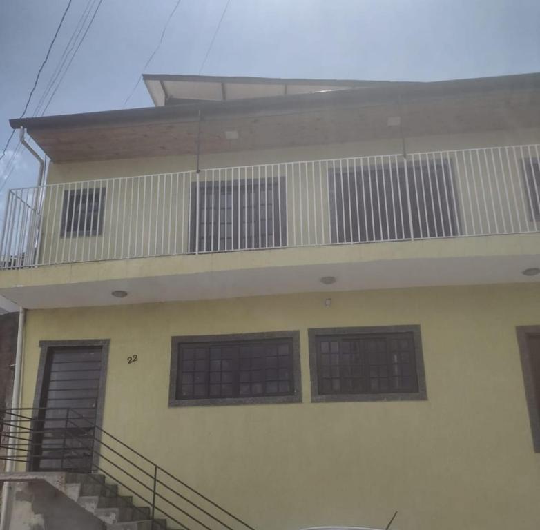 - un bâtiment avec trois fenêtres et un balcon dans l'établissement My Yellow House aconchego, à Campos do Jordão