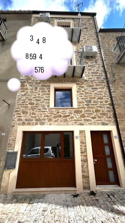 a building with a garage with a sign on it at La Spiga in Gangi