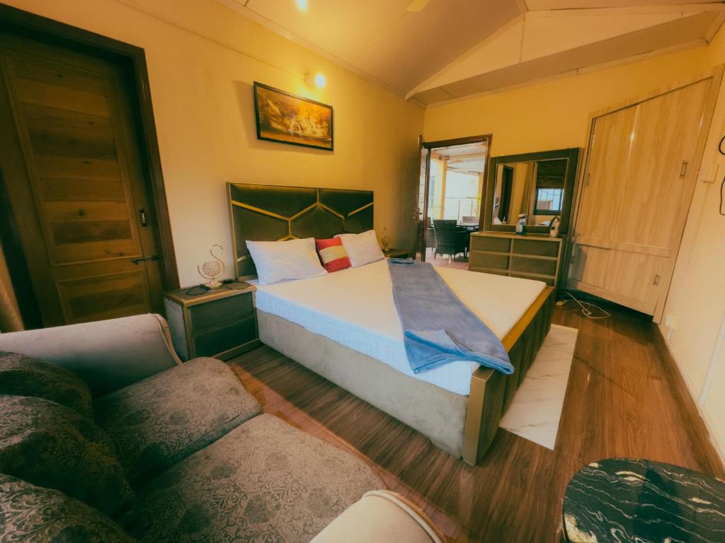 a bedroom with a large bed and a couch at Sapphire Lodges in Muzaffarabad