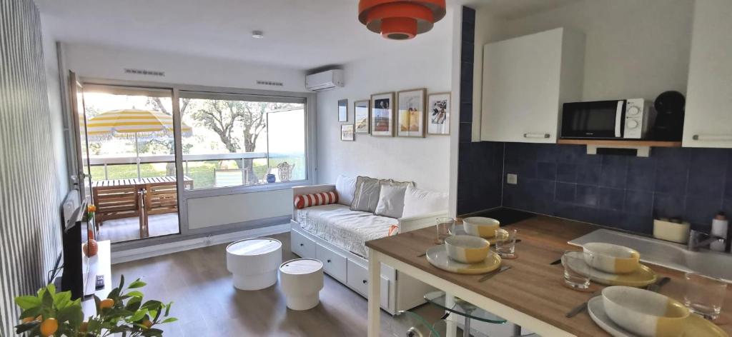 une cuisine et un salon avec un canapé et une table dans l'établissement Escale en Méditerranée, swimmingpool, terrace,AC, à Antibes