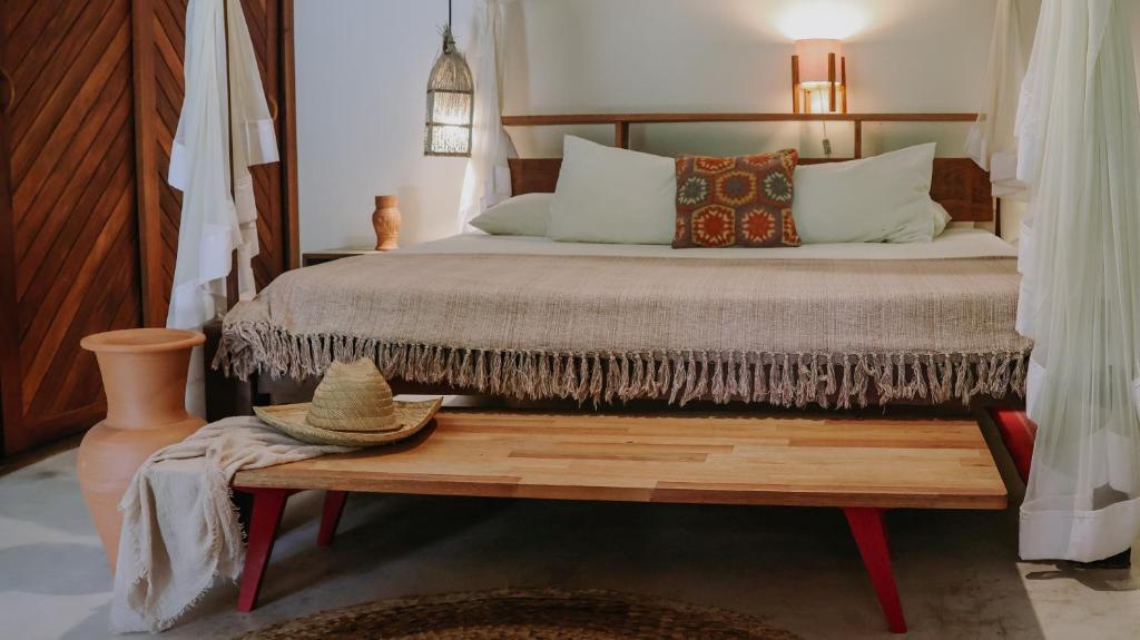 a bedroom with a bed and a table with a hat on it at Na Villa dos Algodões in Marau