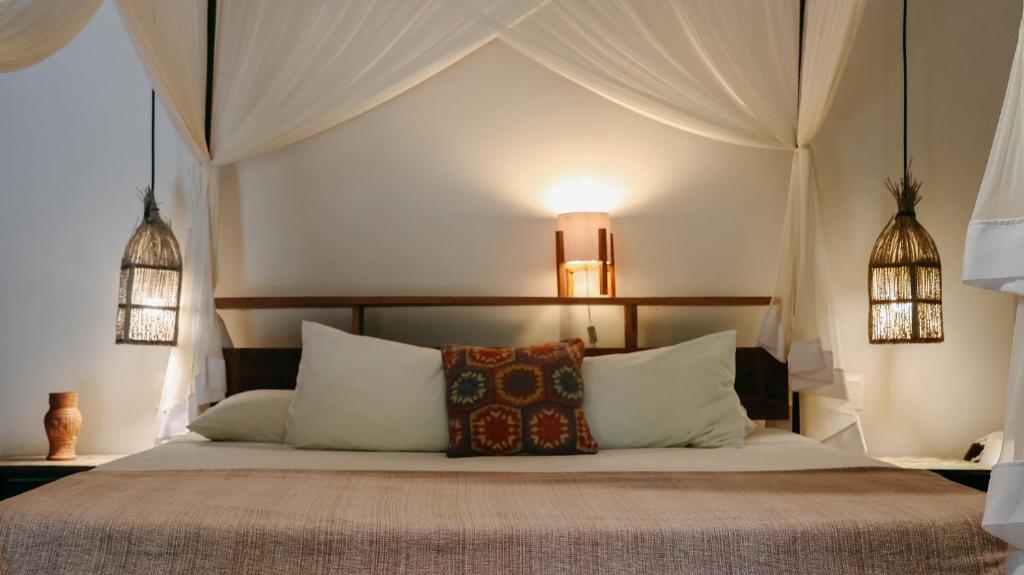a bedroom with a bed with white pillows at Na Villa dos Algodões in Marau