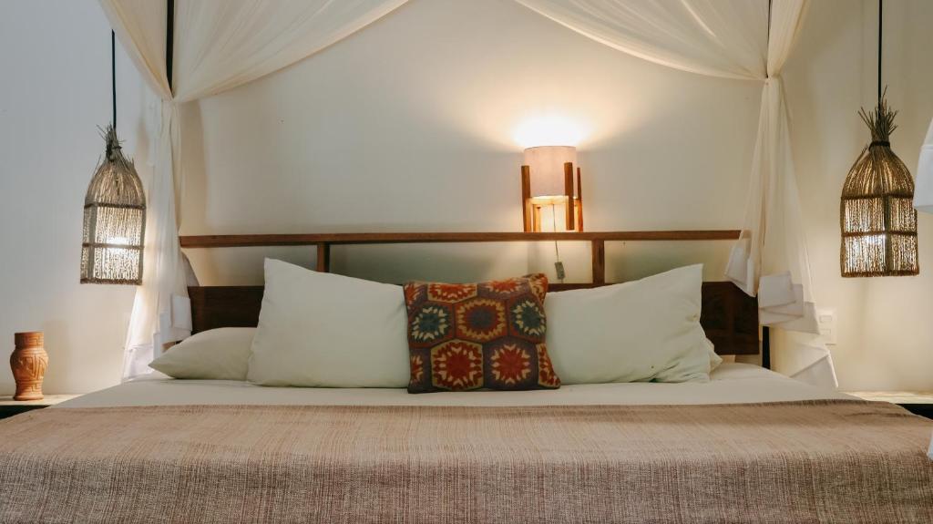 a bedroom with a bed with pillows on it at Na Villa dos Algodões in Marau