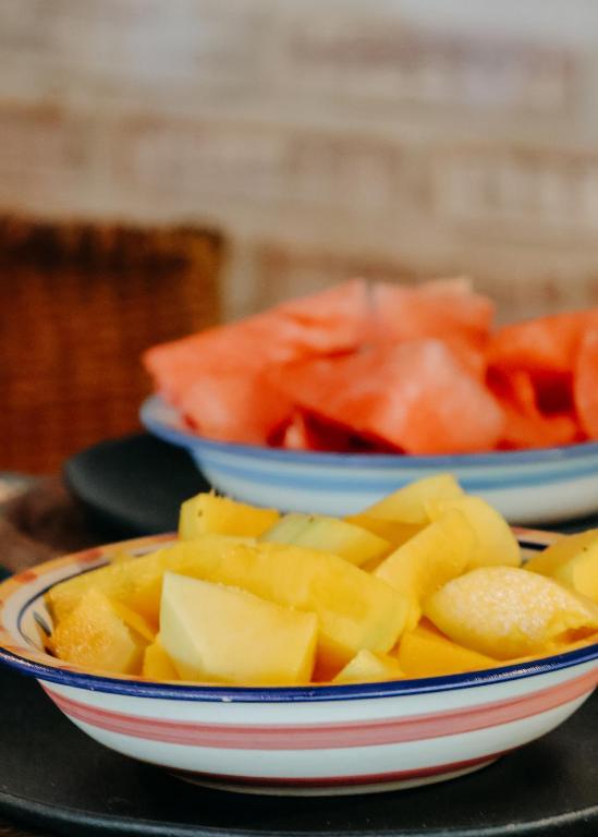 two bowls of food on a table with fruit at Na Villa dos Algodões in Marau