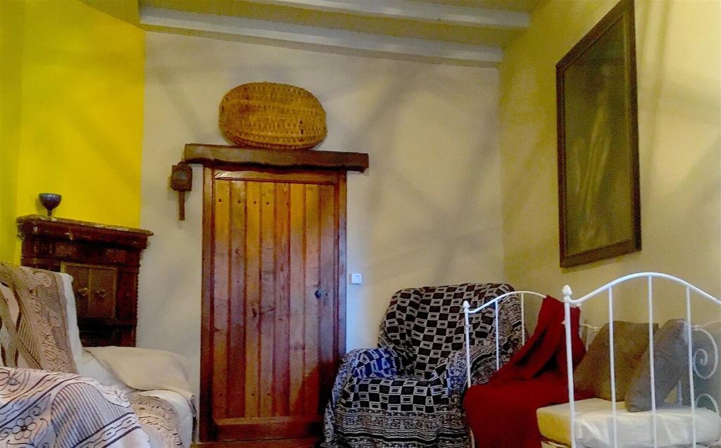 - un salon avec une chaise et une porte en bois dans l'établissement La maison de vacances, à Lalizolle