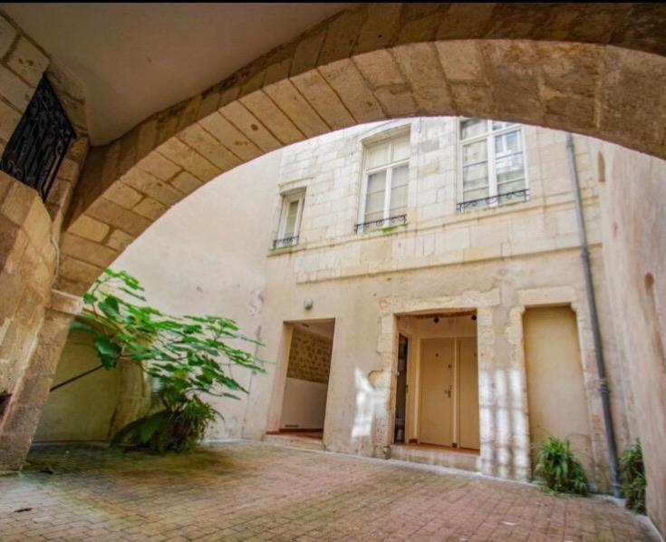 ein Steingebäude mit einem Torbogen davor in der Unterkunft Charmant appartement au coeur de la ville in La Rochelle