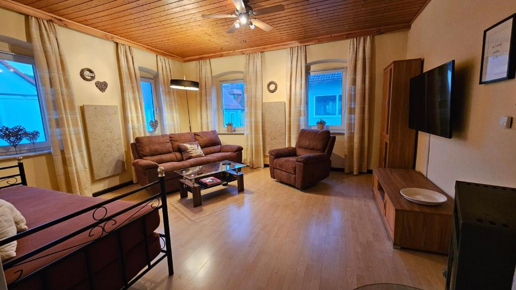 a living room with two chairs and a tv at Ferienwohnungen zur Post - 102 in Weidenberg