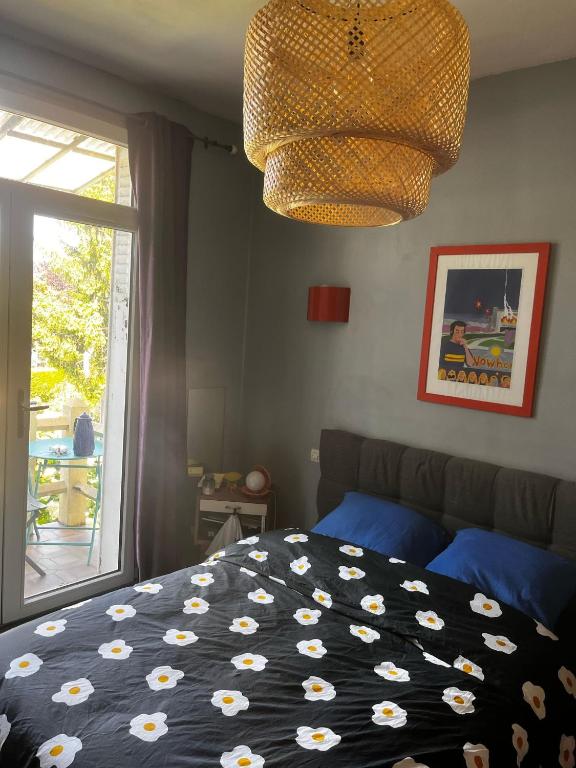 une chambre avec un lit, une fenêtre et un lustre dans l'établissement Cyrus House, au Mans