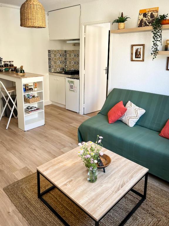 un salon avec un canapé vert et une table dans l'établissement Casa Bazille, à Montpellier
