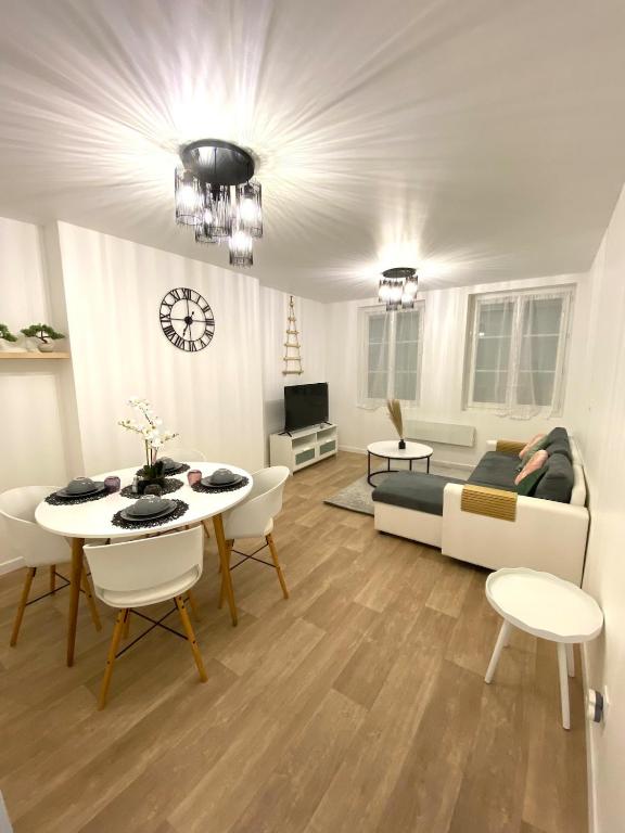 un soggiorno con un tavolo e un divano di Comme à la maison, en Normandie a Gruchet-le-Valasse