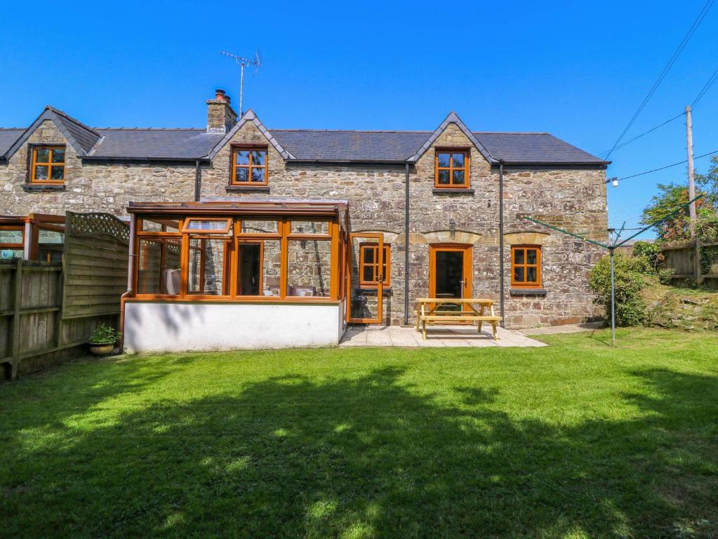une vieille maison en pierre avec une grande cour dans l'établissement Cove Cottage, à Llandysul