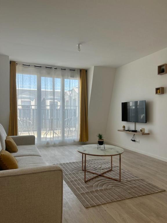 un salon avec un canapé et une table dans l'établissement Appartement cosy T2 avec balcon proche de CDG et de Paris, au Blanc-Mesnil
