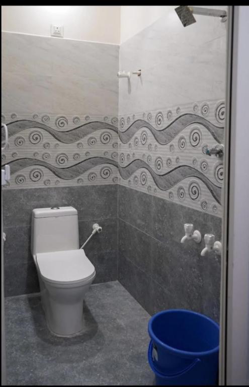 bagno con servizi igienici e secchio blu di M R Lodge a Tiruvannāmalai