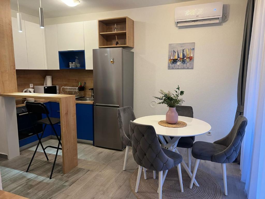 Una pequeña cocina con una mesa y un refrigerador. en Budva APT, en Budva