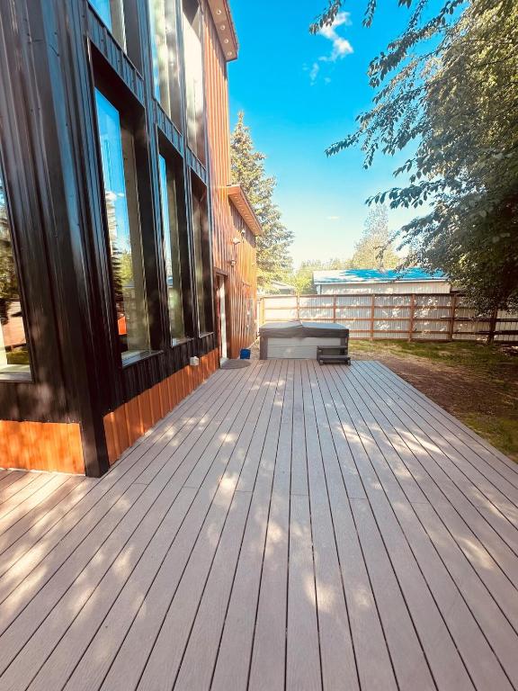 a wooden deck with a bench on the side of a building at Mary s house in Fairbanks