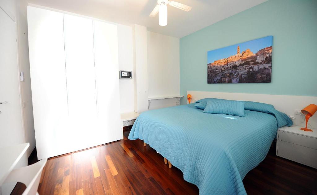 una camera con un letto blu e un dipinto sul muro di amaranto bnb a Matera