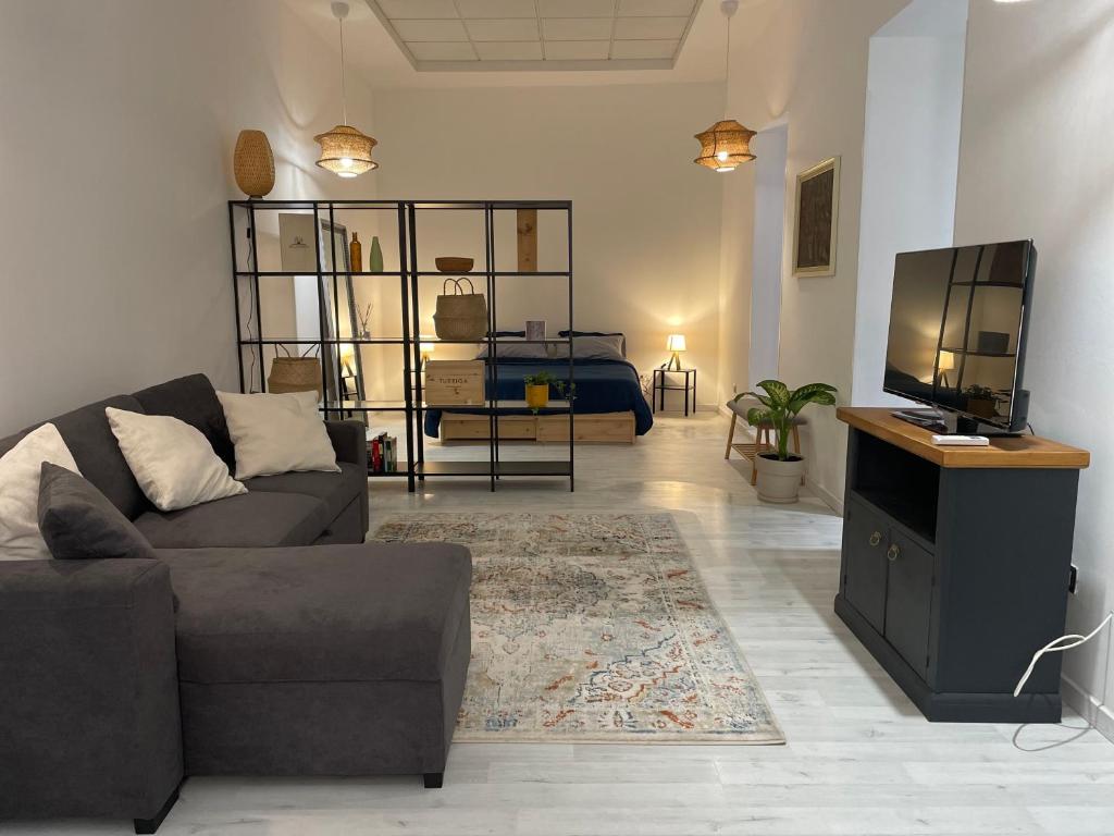 Una sala de estar con un sofá y un televisor de pantalla plana. en Casa Marina 1, en Cagliari