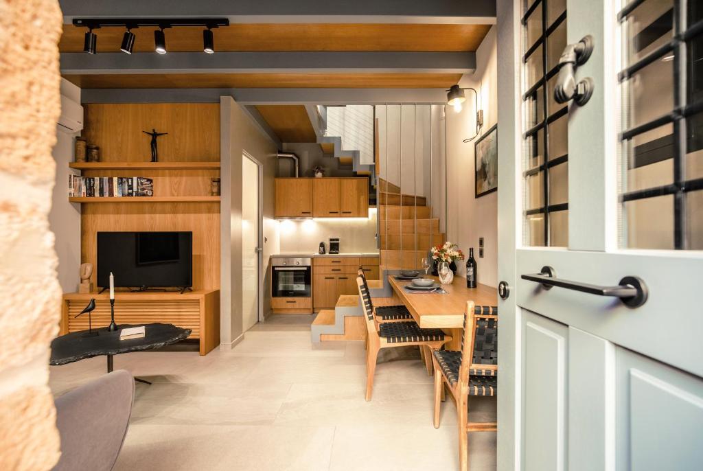 una cucina e una sala da pranzo con tavolo e sedie di The Peach House a Chania