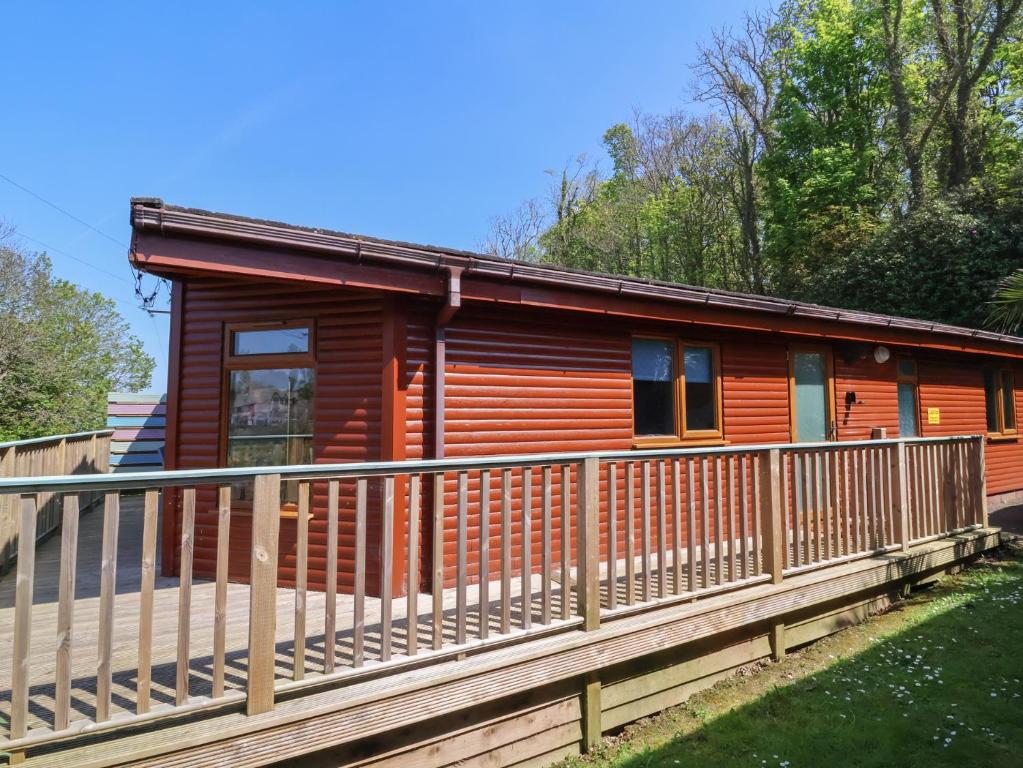 une cabane en rondins entourée d'une clôture en bois. dans l'établissement The Beach House, à Ilfracombe
